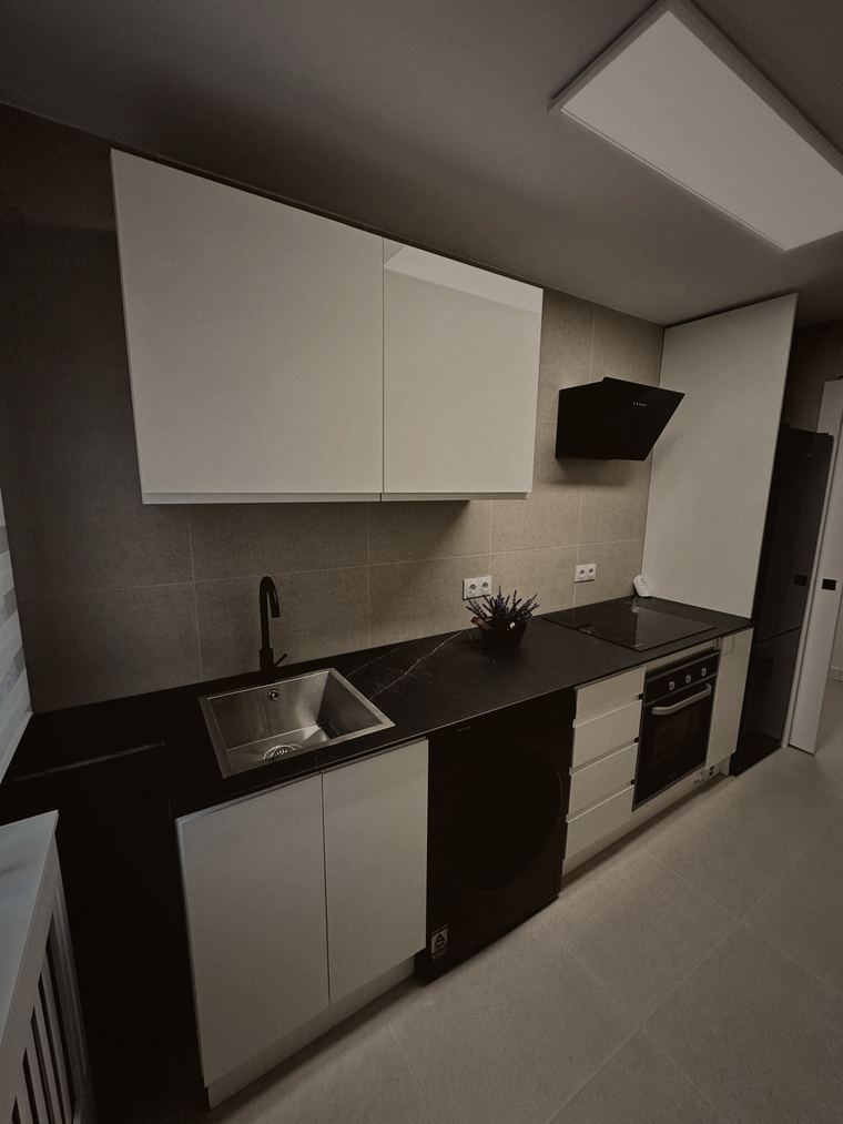 Cocina terminada con encimera negra y electrodomésticos integrados
